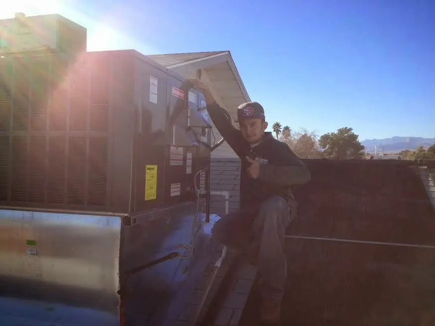 HVAC technician performing Heat Pump Repair on a rooftop unit in North Little Rock